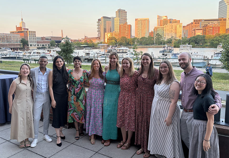 Photo of Fellowship Graduation Class of 2026 standing outside with city skyline in background